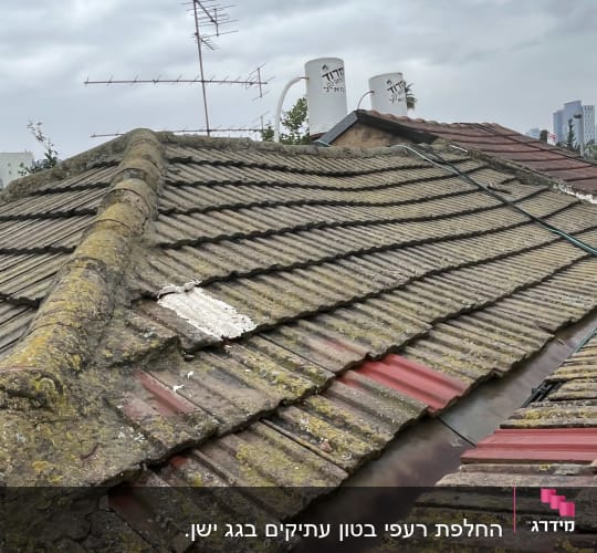 גג רעפים ישן עם אנטנות ומיכלי מים